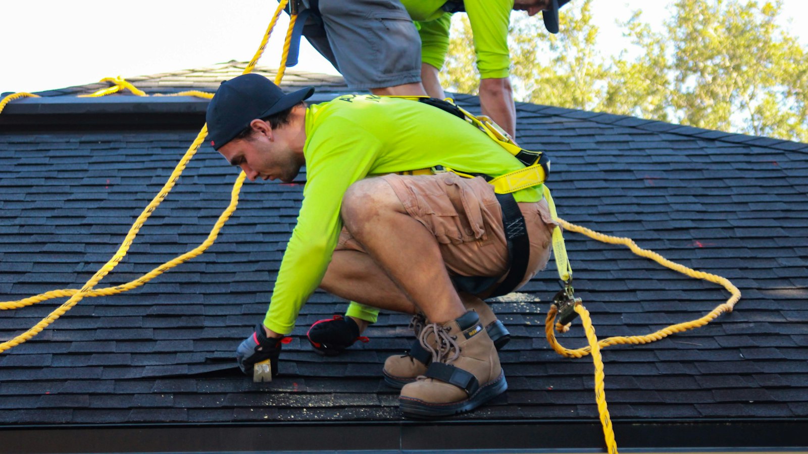 Roofers working on a shingle roof